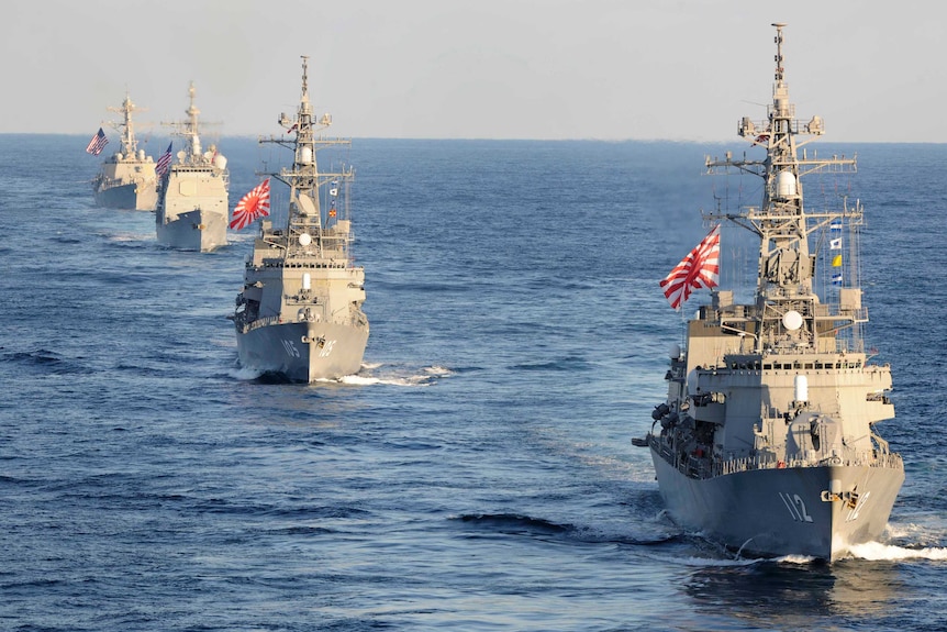 Military ships with the US dan Japan flags in the ocean