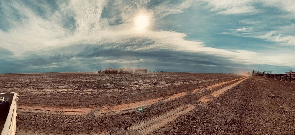 A dusty truck moves across the land