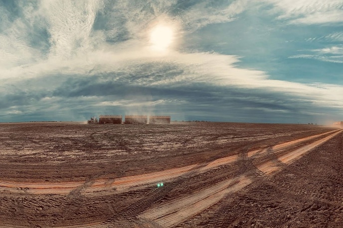 A dusty truck moves across the land