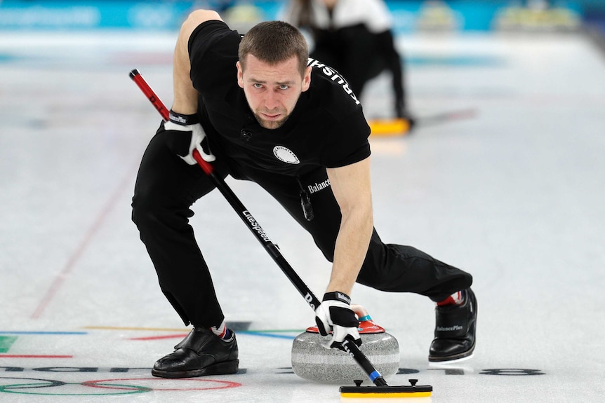 Russia's Alexander Krushelnitsky sweeps ice during mixed doubles curling match against Norway.