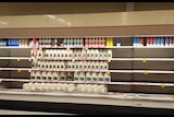 Empty fridge shelves in supermarket with just upermarkets own brands left