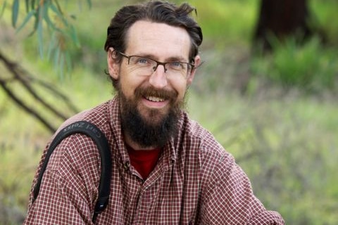 A man with a beard smiling.