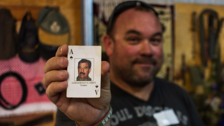Brian Willcox holds Saddam Hussein ace of spades playing card
