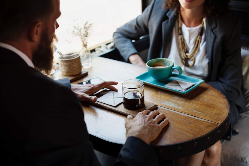 Two people having coffee in a cafe and working.