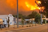 A hill on fire in the background with the Walwa Bush Nursing Centre in the foreground.
