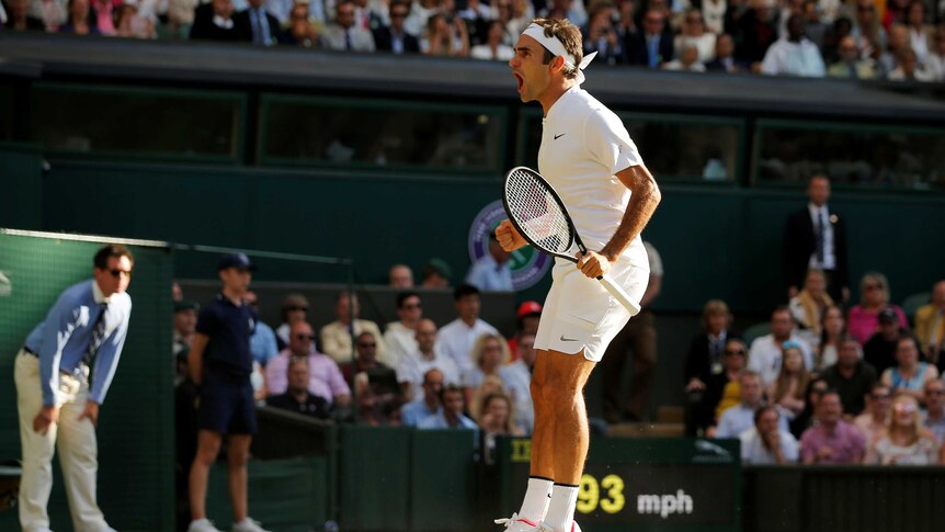 Roger Federer jumps in the air with his match open as celebrations winning his Wimbledon quarter-final.