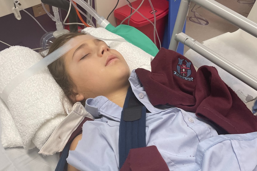 A young girl lying in a hospital bed