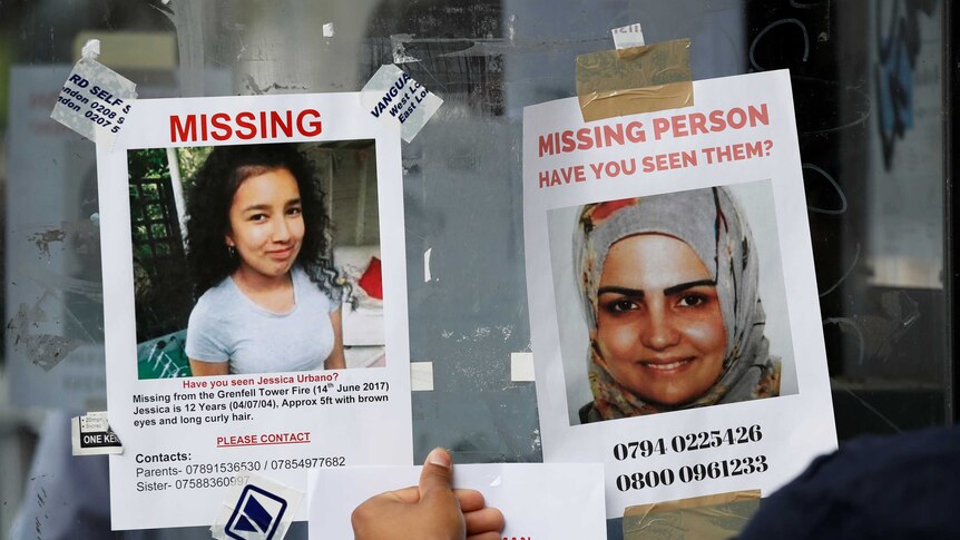 A hand appearing to stick a poster beneath two missing persons posters picturing a young woman and girl.