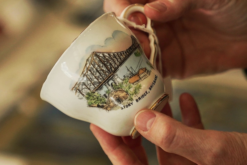 A delicate tea cup with a picture of the Story Bridge.