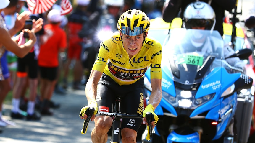 A man on a bike in a yellow jersey