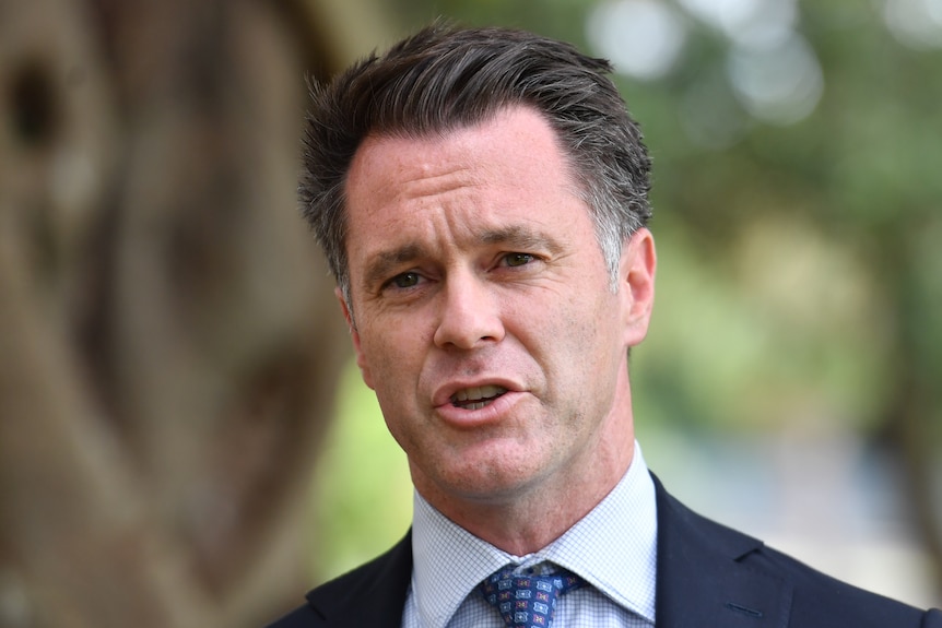 Close-up of a man in a suit and tie talking. 