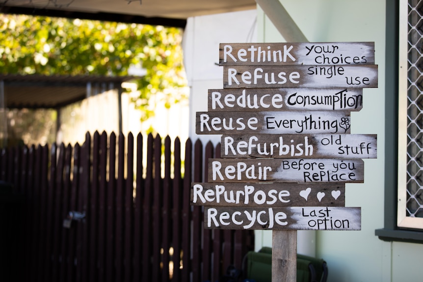 A sign saying rethink, refuse, reduce, reuse, refurbish, repair, repurpose, recycle.