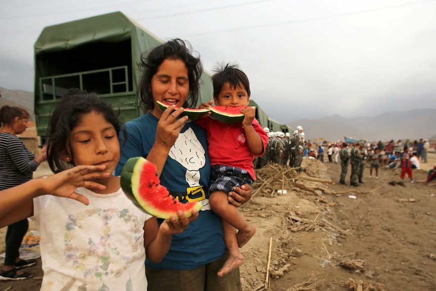 Three flood survivors eat food.