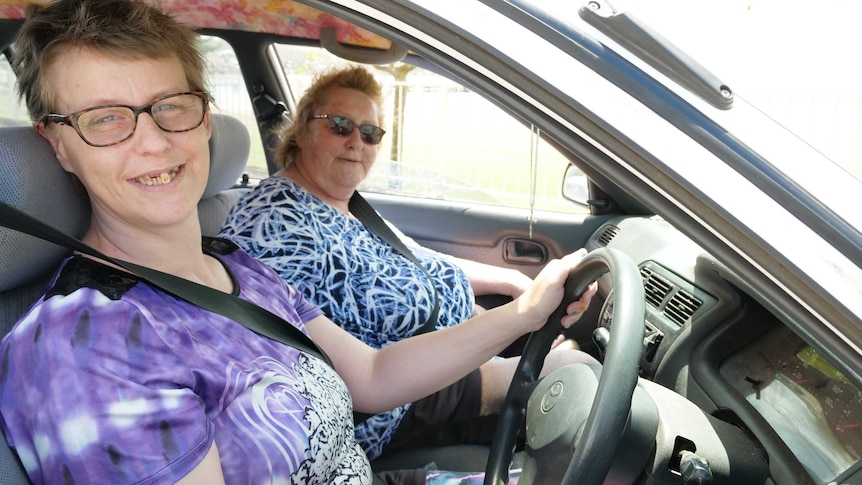 Two women sitting in car, view through driver's window