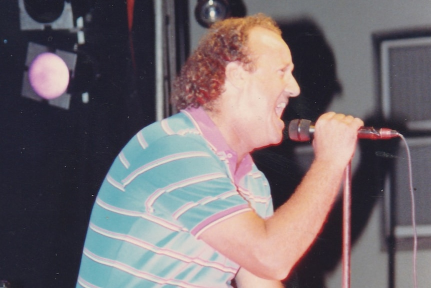 A man sings into a microphone.