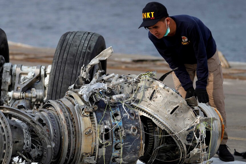 Indonesian National Transportation Safety Commission (KNKT) official examines a turbine engine from the Lion Air flight JT610.