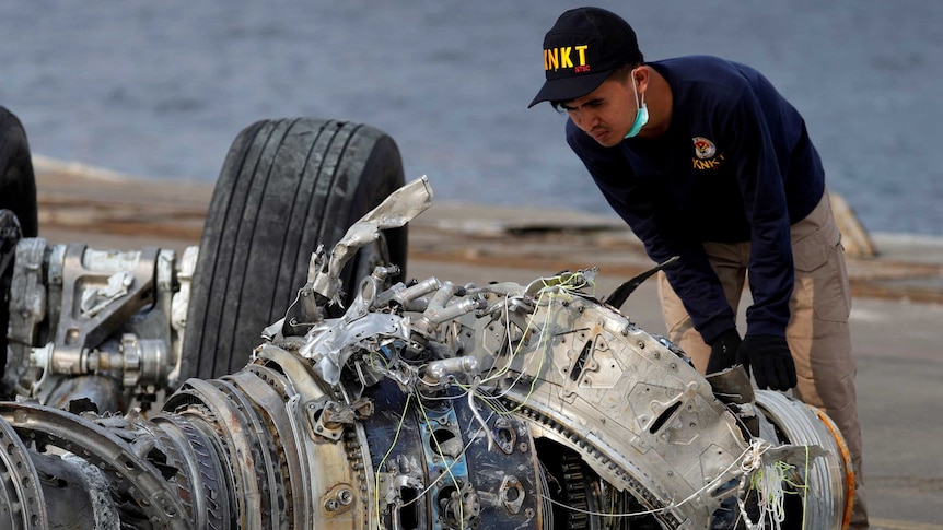 Indonesian National Transportation Safety Commission (KNKT) official examines a turbine engine from the Lion Air flight JT610.