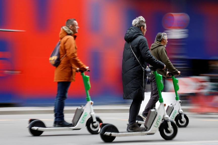 People ride electric scooters in Paris.