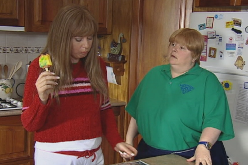 A scene from Kath and Kim with Kim and Sharon standing in a kitchen.