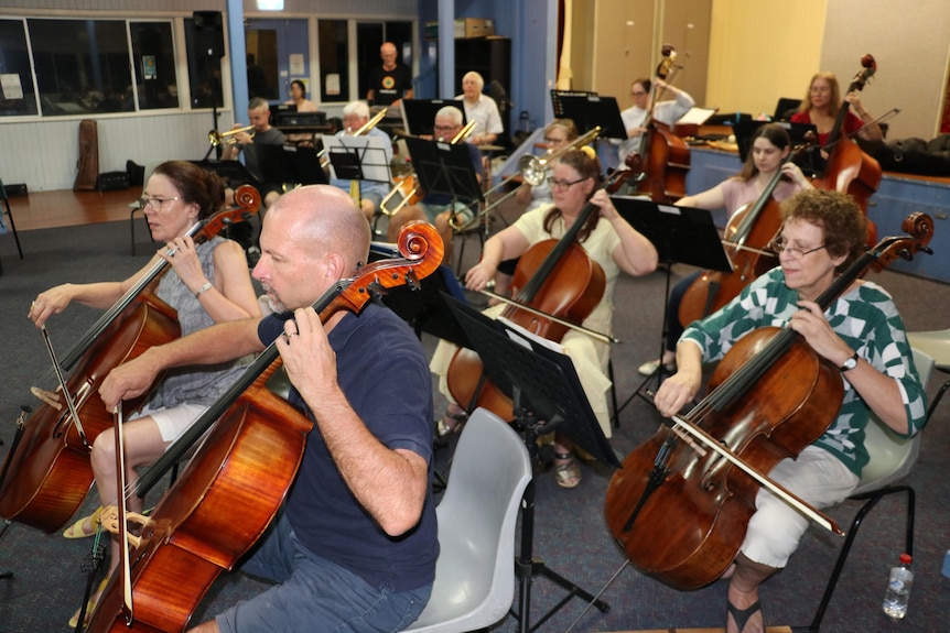 a group of orchestra musicians rehearse together