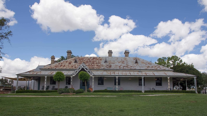 An old Australian homestead with a rusted roof and wide verandah