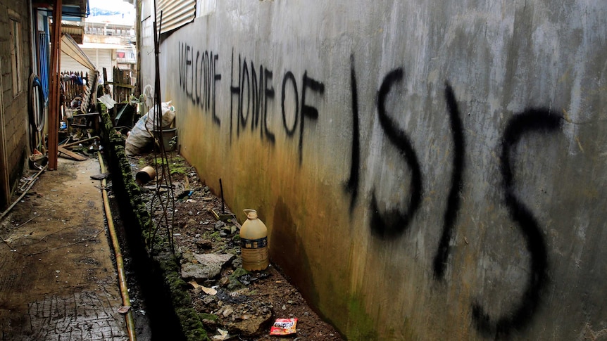 Grafitti that says "Welcome home of ISIS" is seen in a back-alley of Marawi City, in the Philippines.