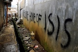 Grafitti that says "Welcome home of ISIS" is seen in a back-alley of Marawi City, in the Philippines.