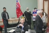 Far-right protesters holding flags and signs disrupt a Yarra Council meeting
