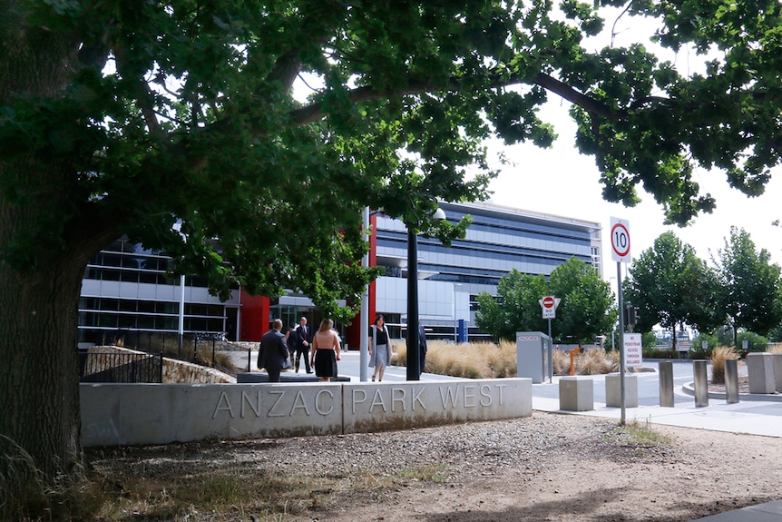 Workers come and go at the modern looking entrance of Anzac Park West.