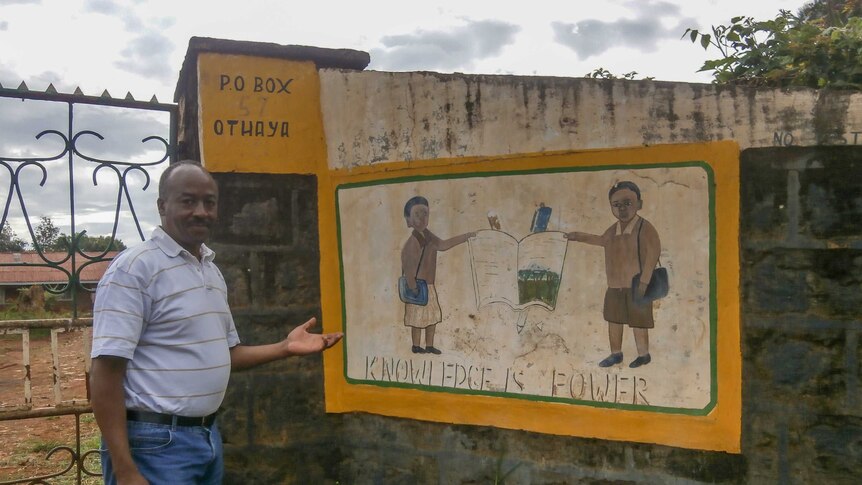 Mutuota Kigotho posing outside his childhood school in Kenya