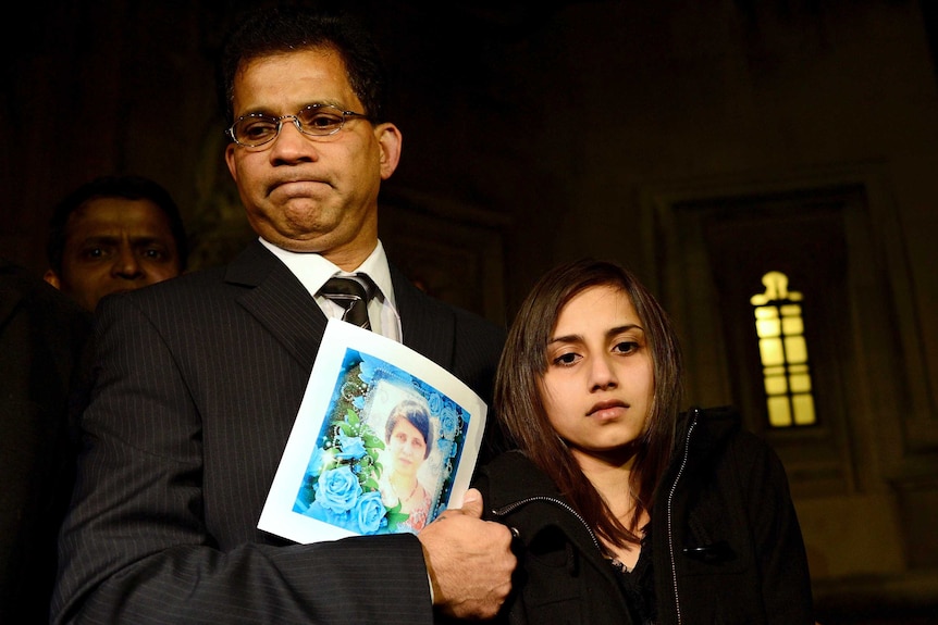 Ben Barboza stands with daughter Lisha as he holds a picture of wife Jacintha Saldanha.