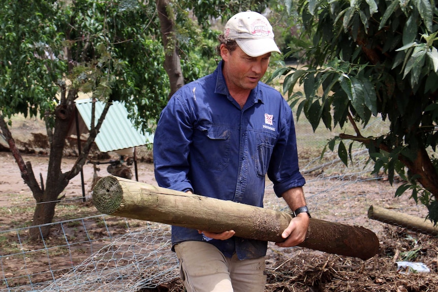 Jonathon Correll moves a damaged fence post.