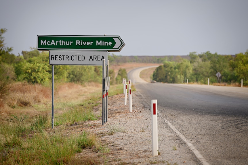 Una señal de tráfico al costado de una carretera apunta hacia la mina del río McArthur. 