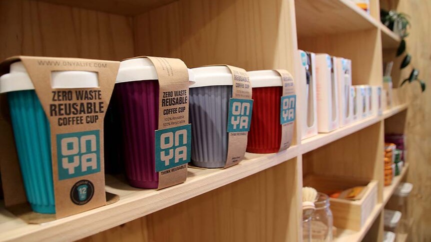 Reusable coffee cups on a shelf in a shop