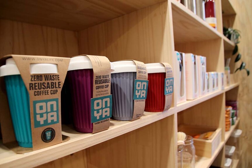 Reusable coffee cups on a shelf in a shop