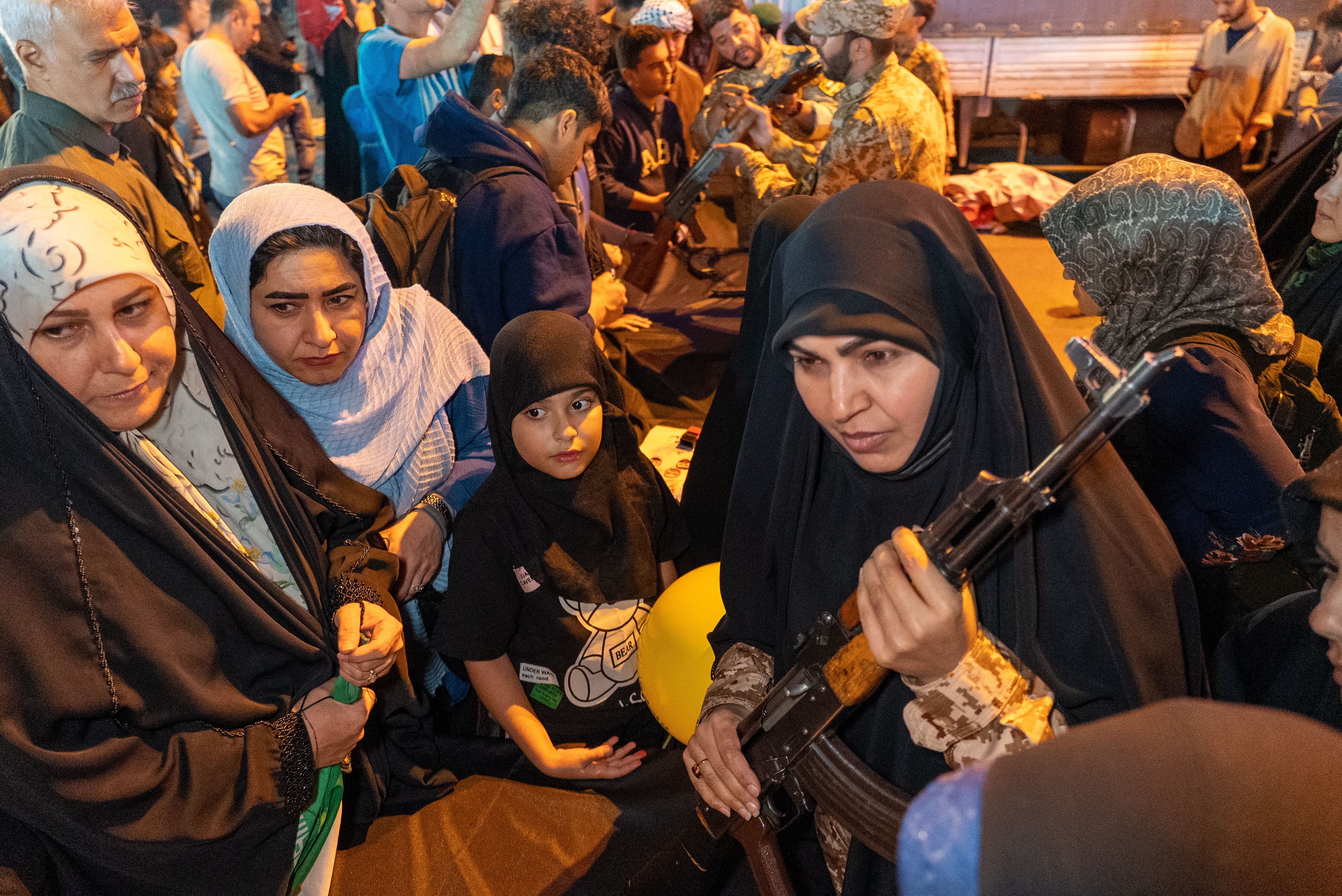 A woman instructing a group of women about firearms while holding a rifle.