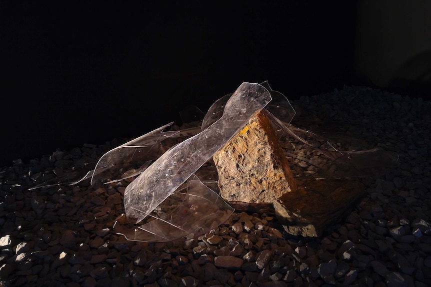 Still from kick the dust videon by Vernon Ah Kee - featuring broken glass and concrete