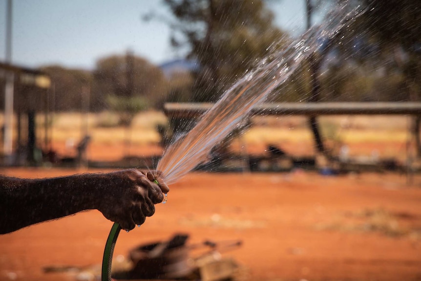 Water spraying from hose in a remote Indigenous community