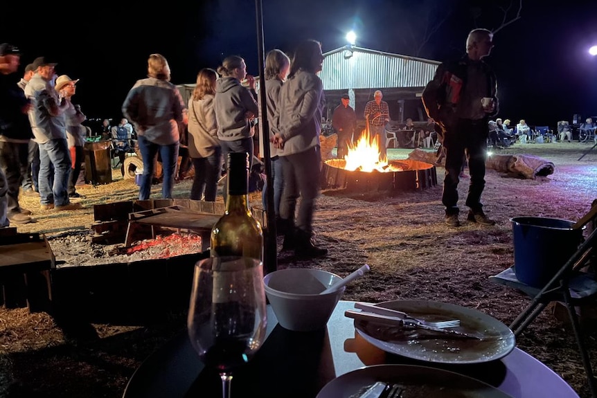 Campers stand around the camp fire at Lara wetlands