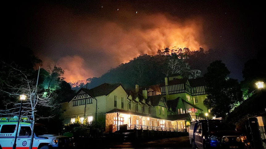 Jenolan Caves House with a glowing silhouette of a mountain in the background.