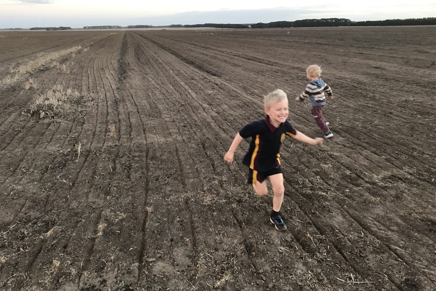 Kirsten's two sons run around a paddock on their farm in country Victoria.
