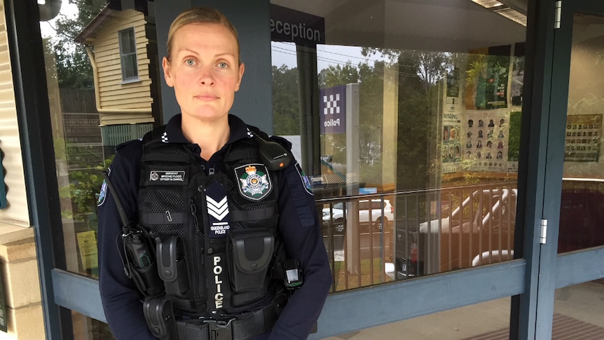 Female police officer standing in front of police station