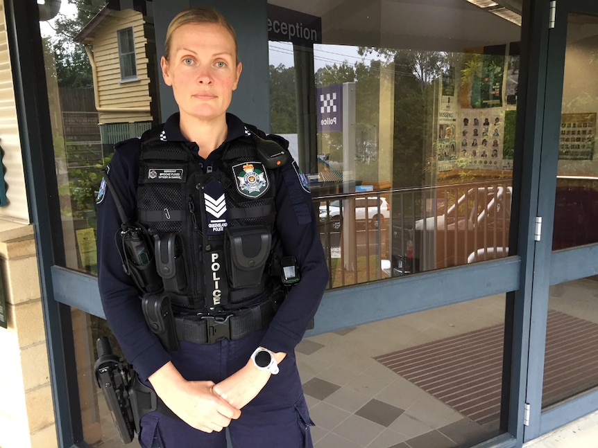 Female police officer standing in front of police station