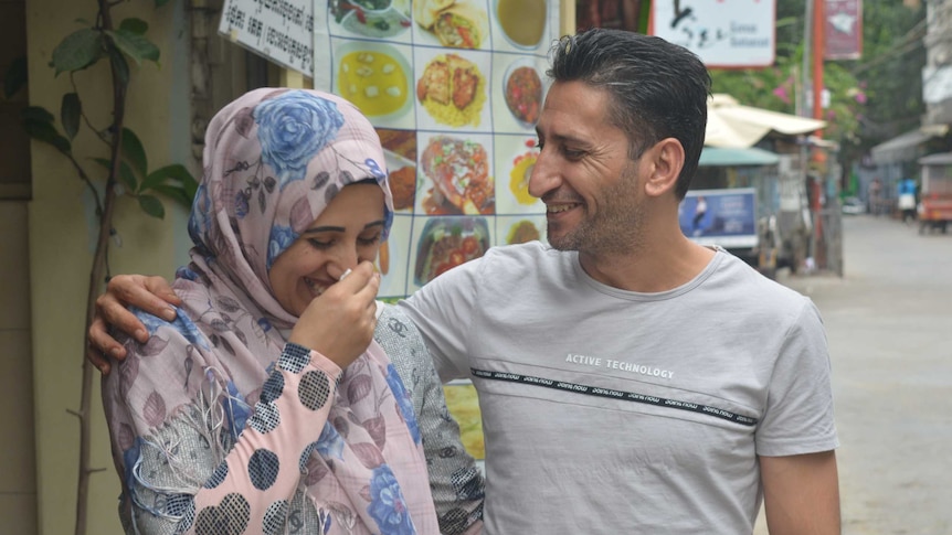 Yasmin Zalghanah and Abdullah embrace and laugh together on a street in Phnom Penh.