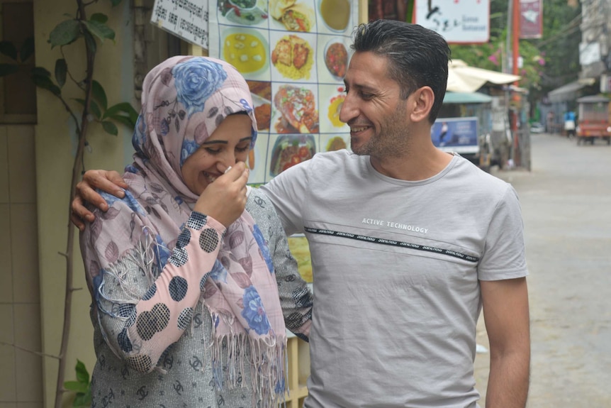 Yasmin Zalghanah and Abdullah embrace and laugh together on a street in Phnom Penh.