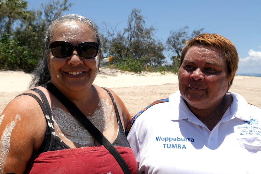 Two Aboriginal women standing on the beach