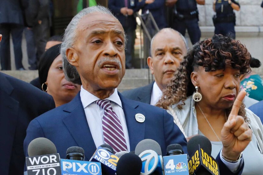 Reverend Al Sharpton speaks at a news conference outside the US Attorney's office, he is pointing his finger.