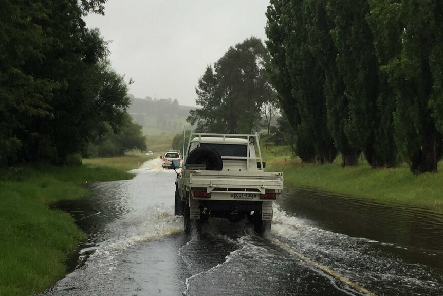 Cars drive through flooded Buckajo Road after heavy rainfall.