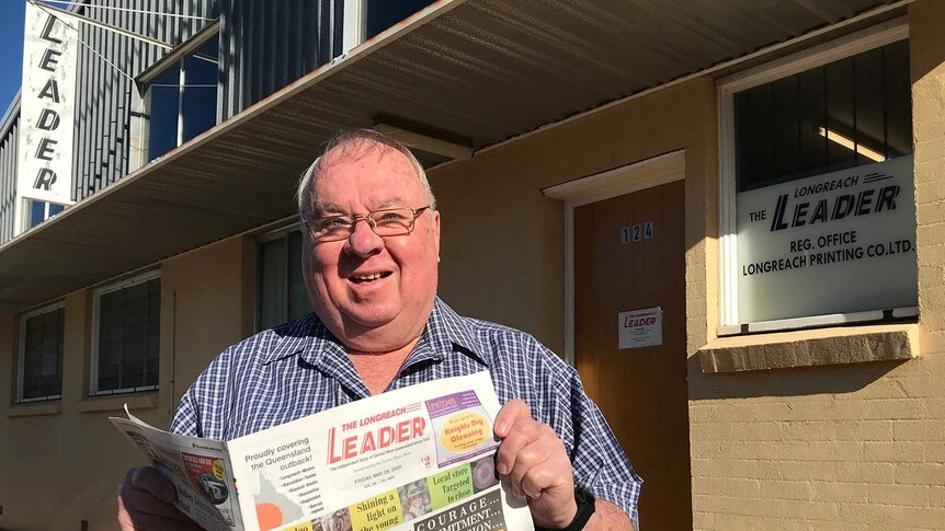 Colin Jackson stands proud in front of the Longreach Leader building with the latest issue of the paper.