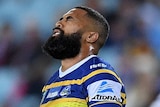 Michael Jennings grimaces with his eyes closed playing for Parramatta against the Sydney Roosters.